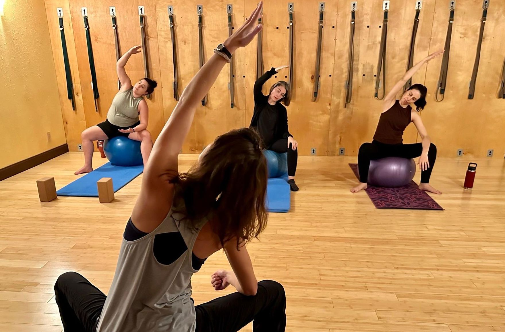 Pilates teaching a student on the ball