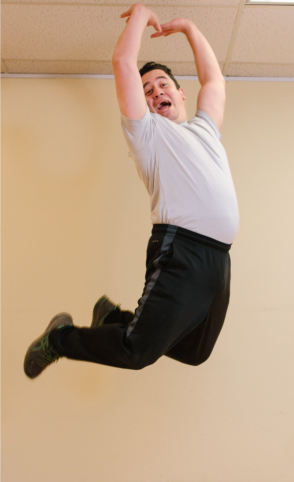 a man in a white shirt and black pants is jumping in the air