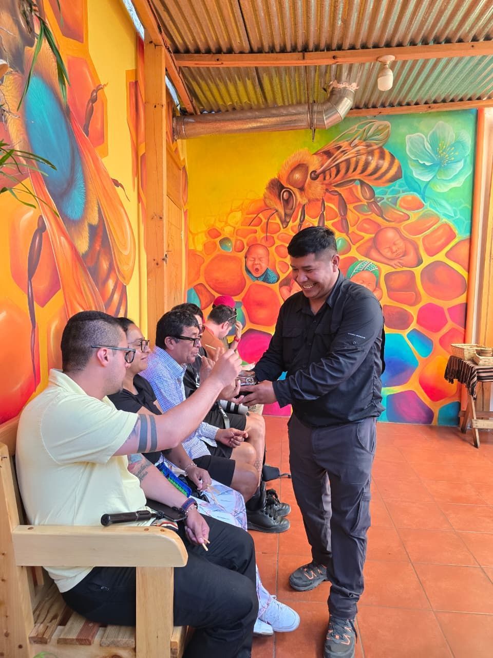 Una pareja se encuentra en la cima de una montaña rocosa con los brazos en alto