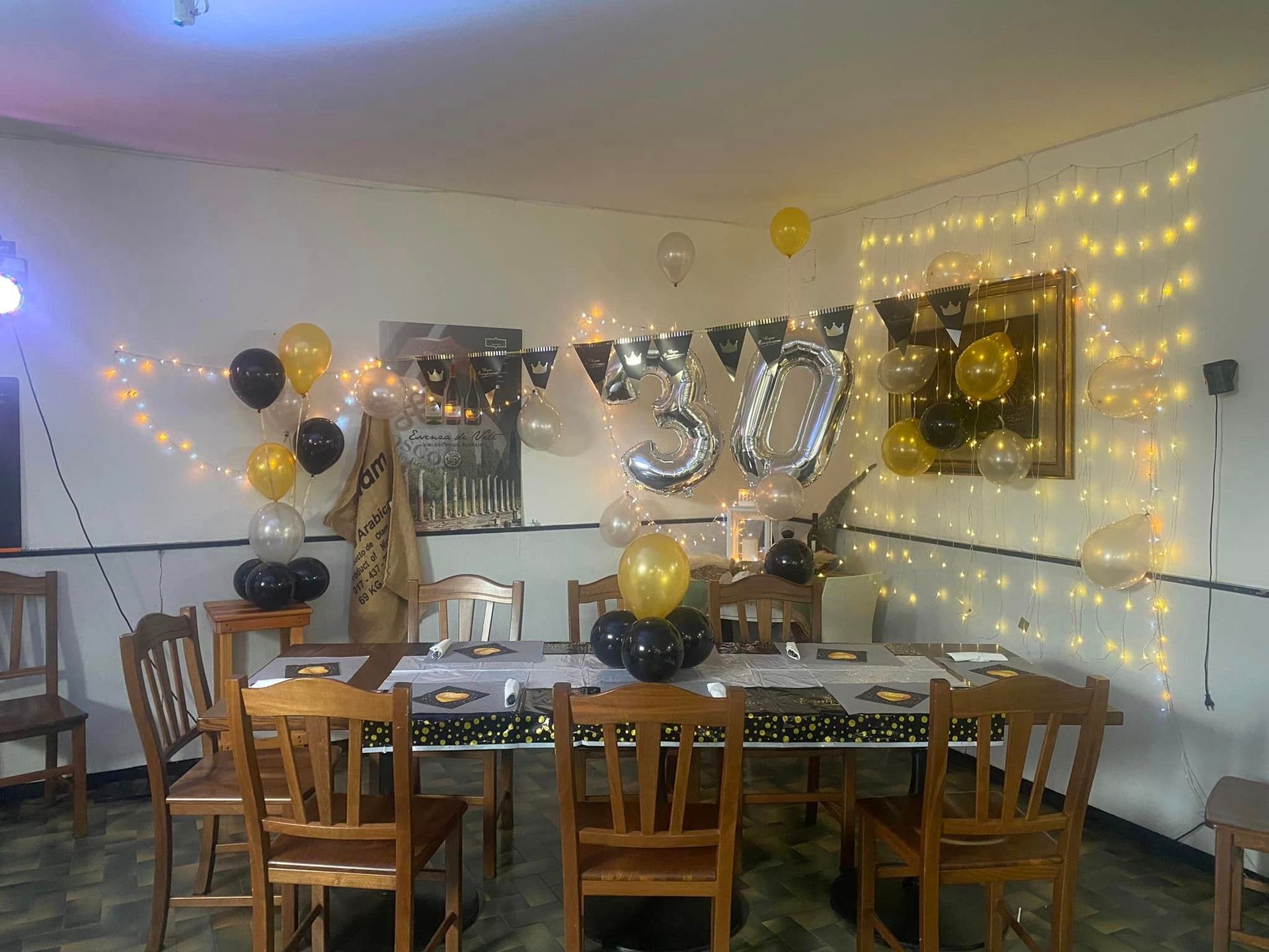 Una stanza con tavolo e sedie addobbata per una festa di trentesimo compleanno.