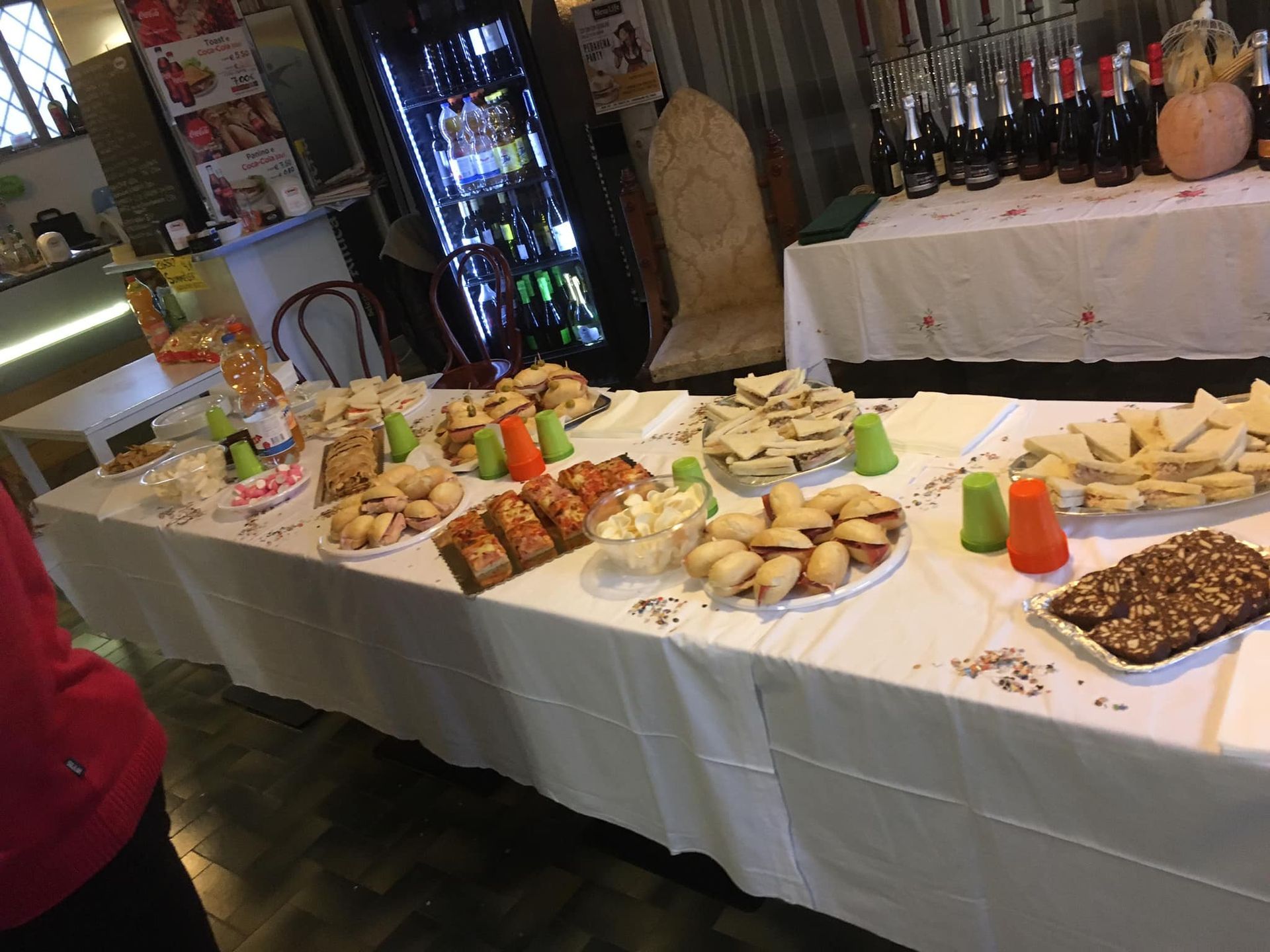 Un lungo tavolo pieno di cibo e bevande.