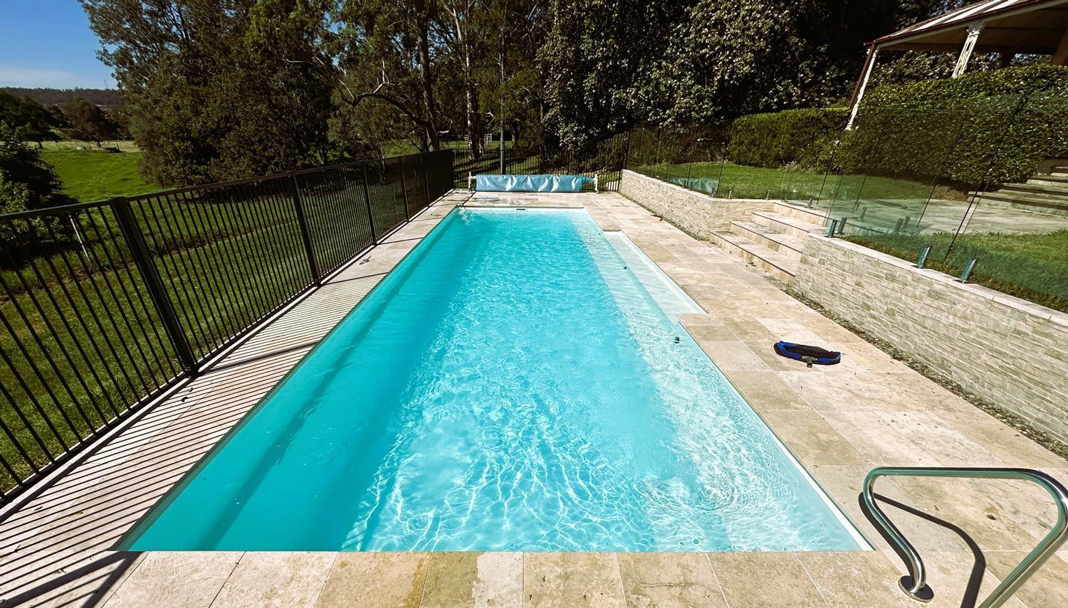 Backyard Swimming Pool with Bright Blue Water, Concrete Deck — Taree Water Works in Taree, NSW