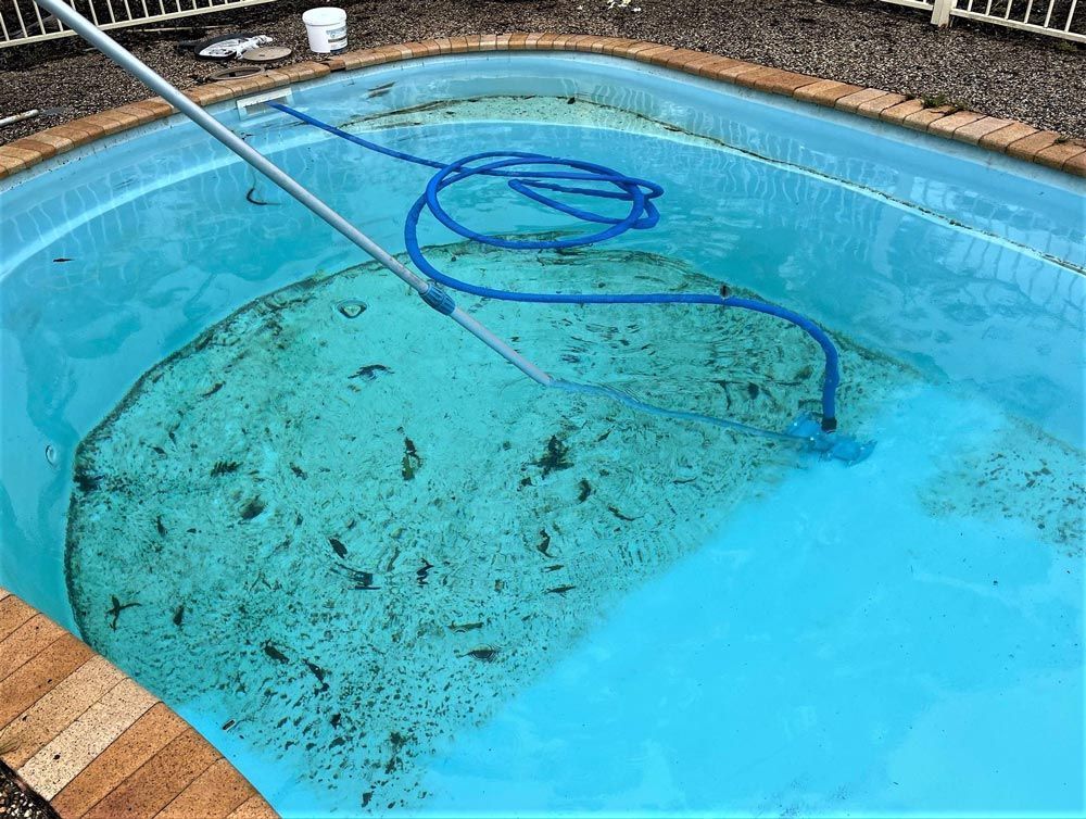 Pool Water Being Vacuumed, with A Blue Hose and Debris Collected on The Floor — Taree Water Works in Taree, NSW