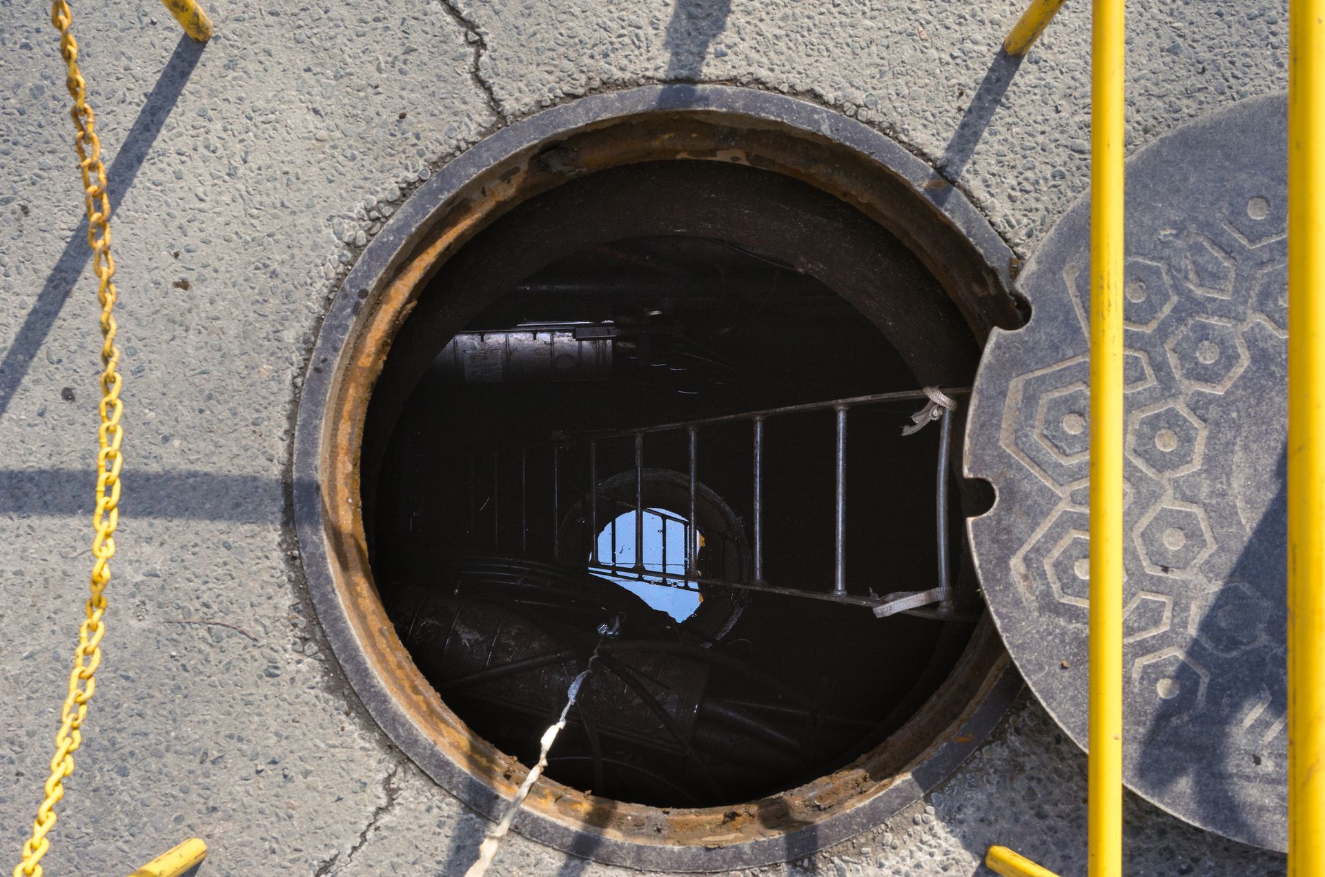 A manhole cover with a ladder going into it