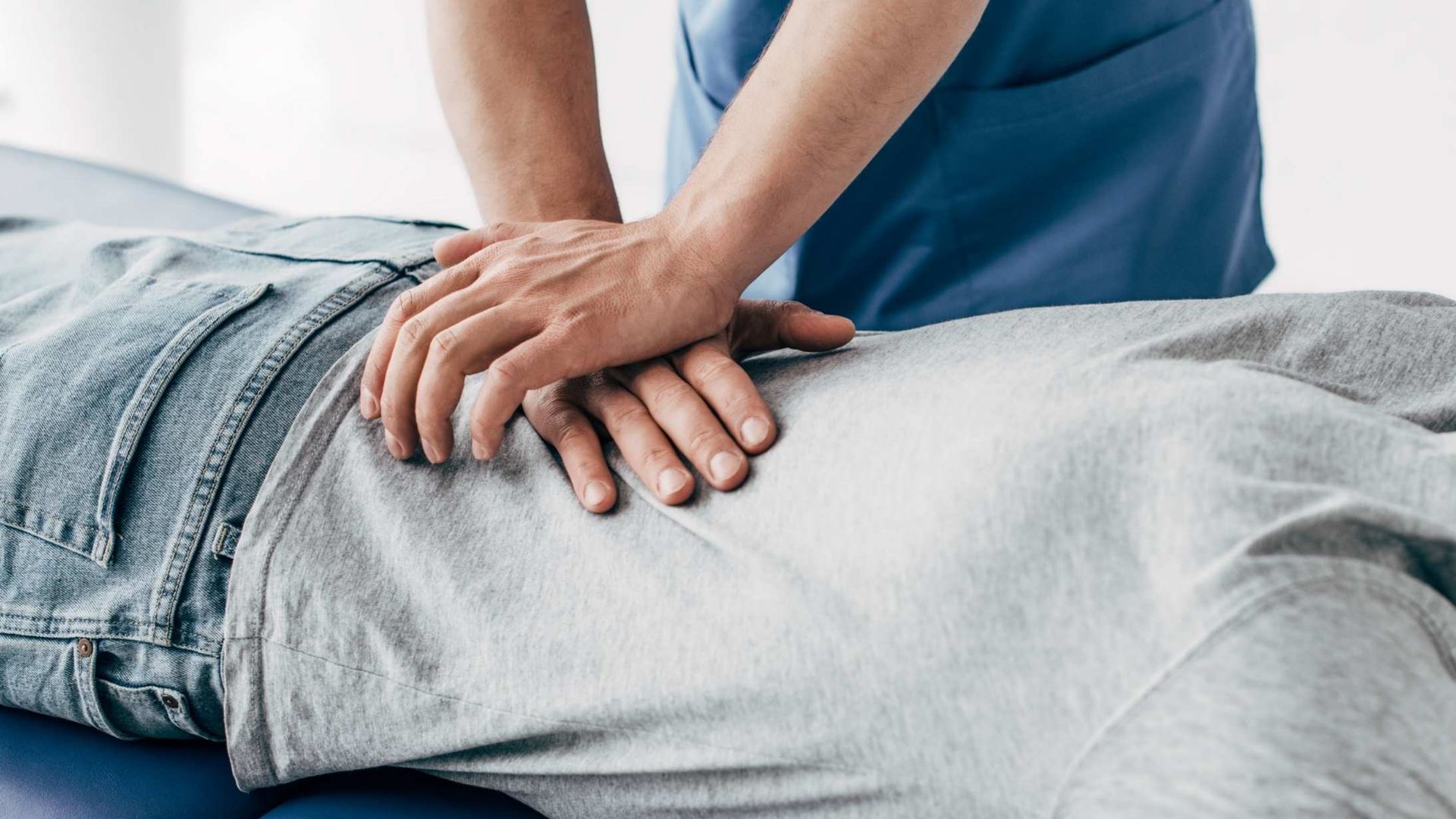 Person receiving lower back massage from a healthcare professional.