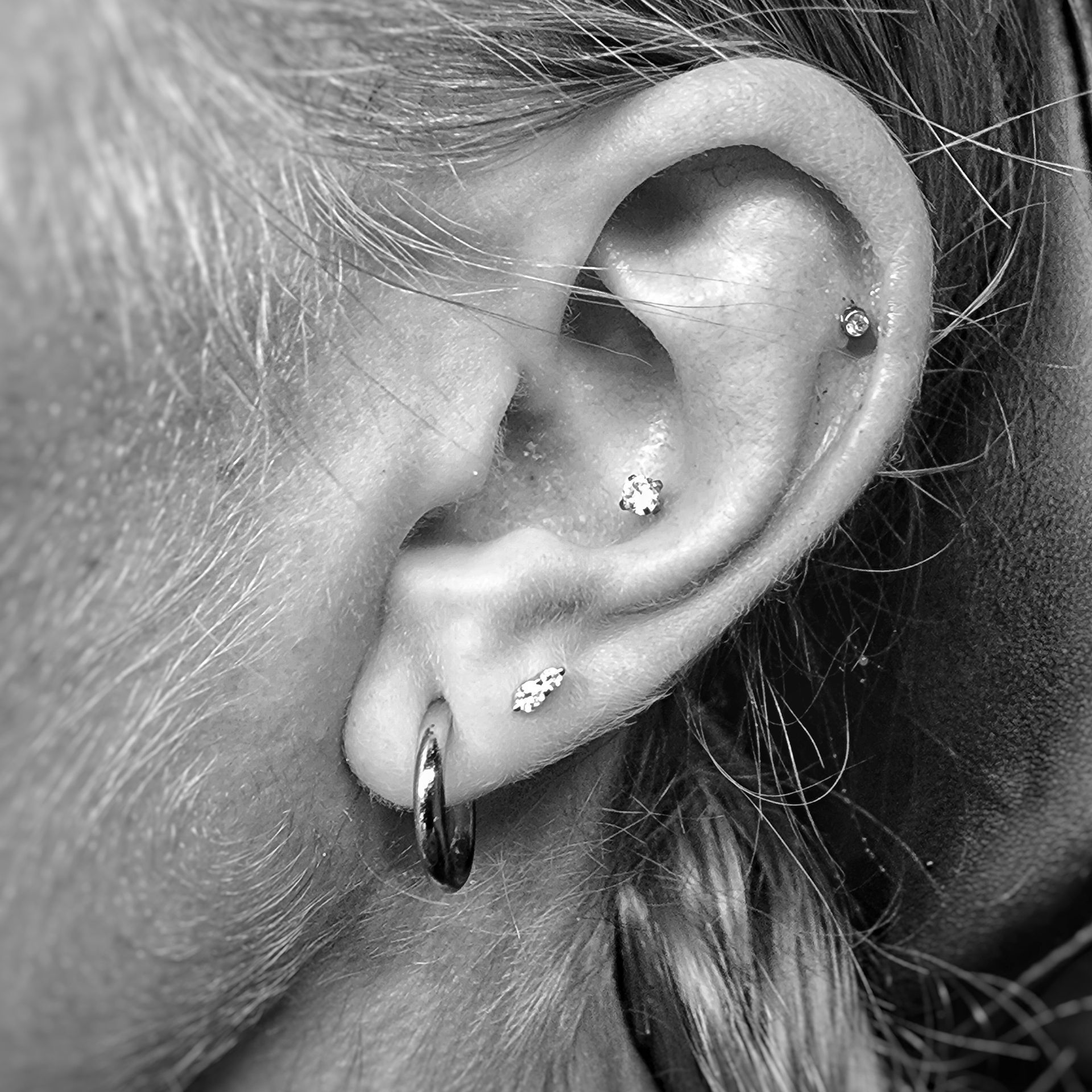 a close up of a woman 's ear with earrings and piercings