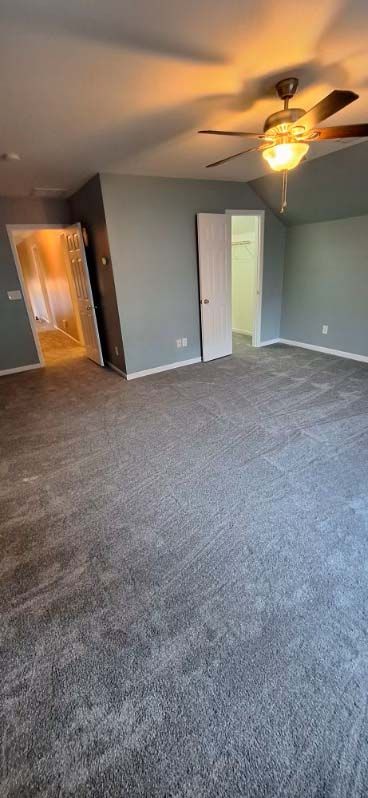 Bedroom with gray walls, carpet, and ceiling fan. Two doorways are visible.
