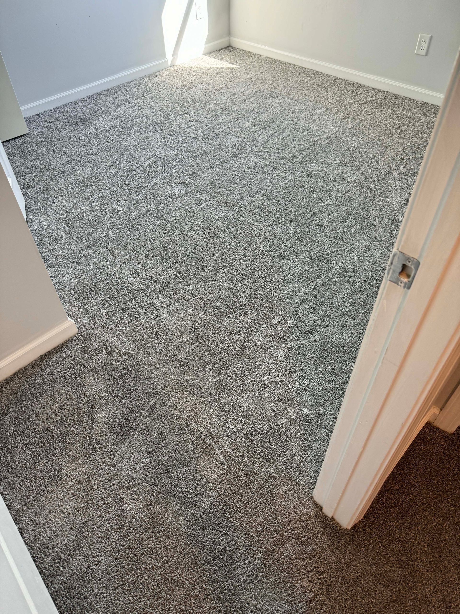 Room with new gray speckled carpet.