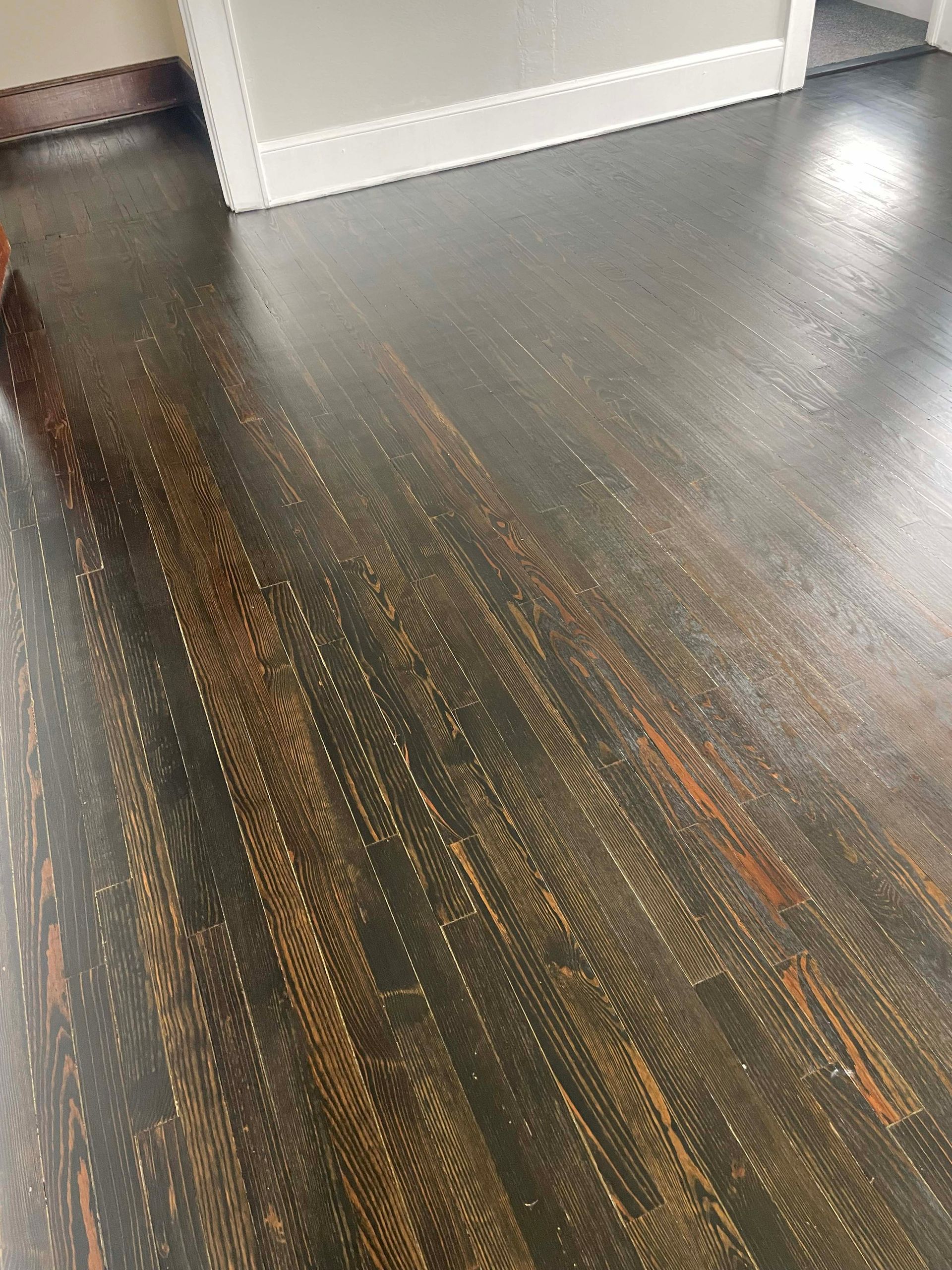 Dark hardwood floor with visible wood grain and distressed finish.