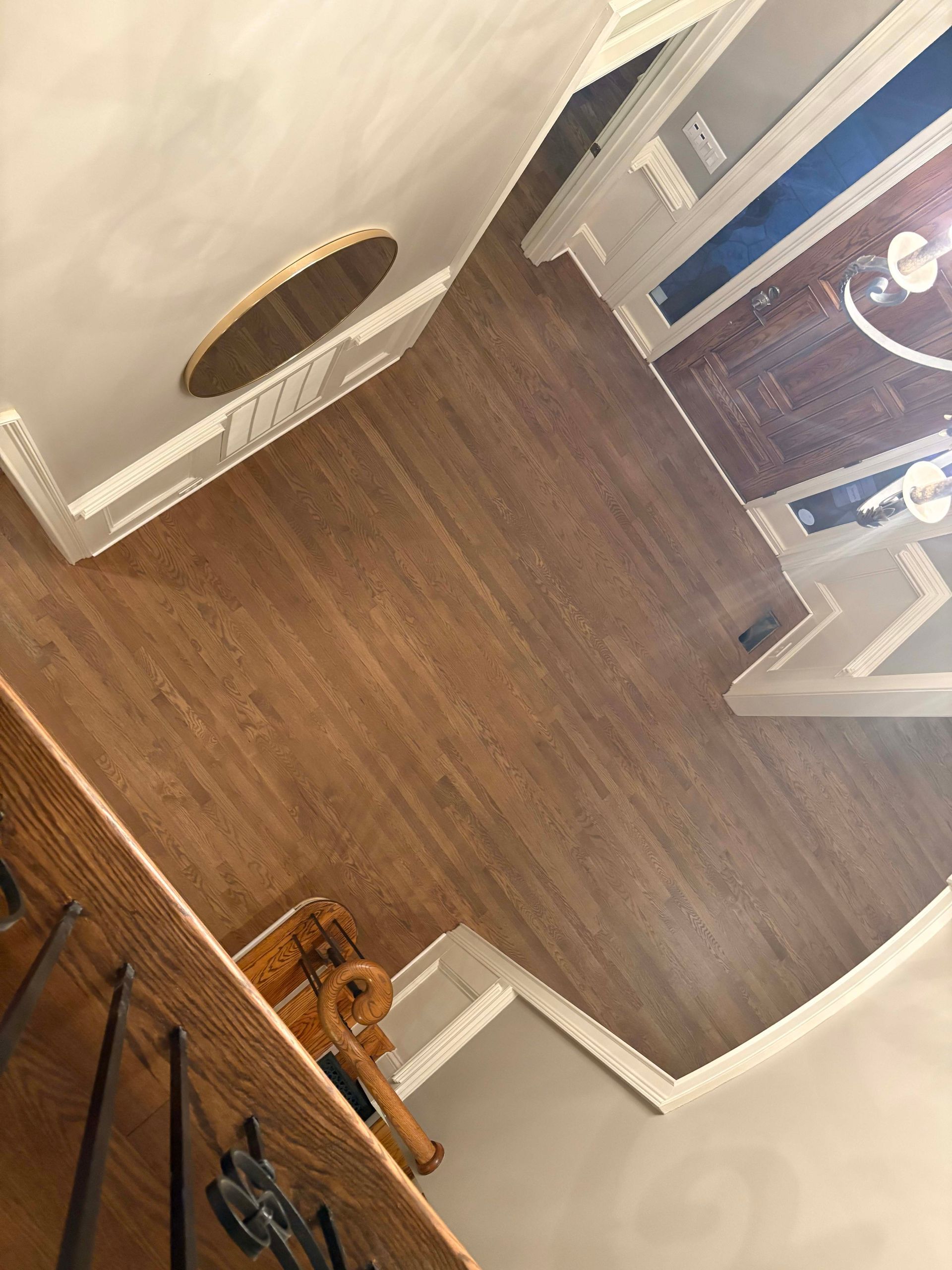 Wooden floor with white trim and a ceiling medallion, looking into another room with a blue wall.