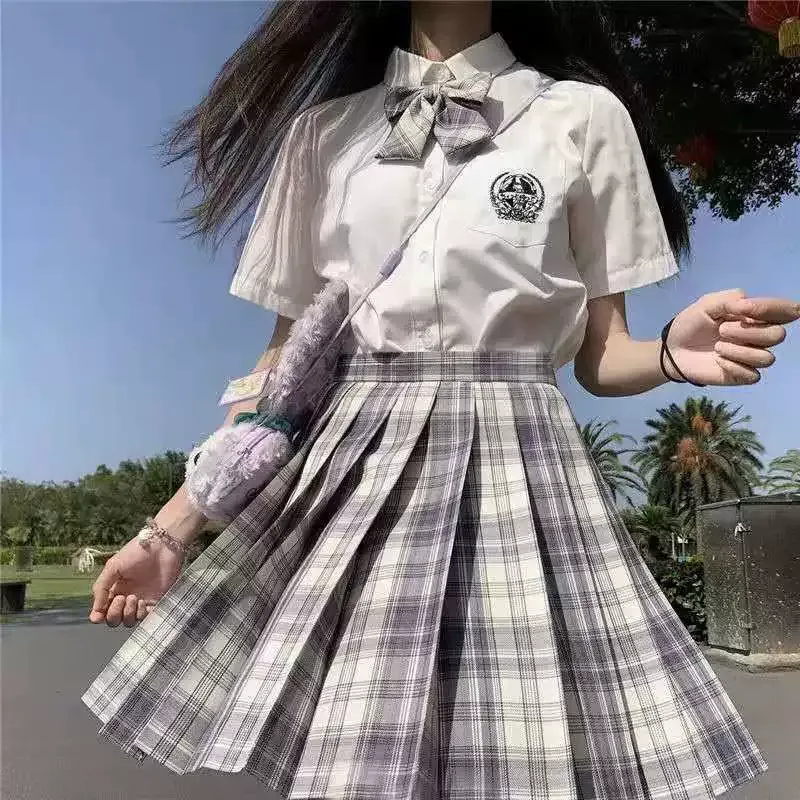 一個女孩穿著格子裙和白襯衫。