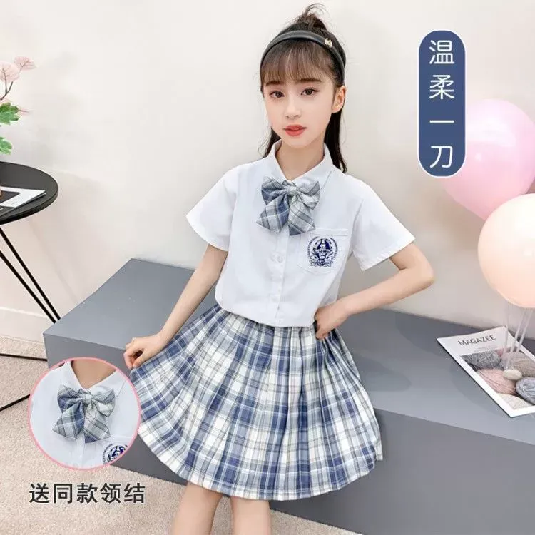 一個小女孩穿著一件白襯衫和一條格子裙。