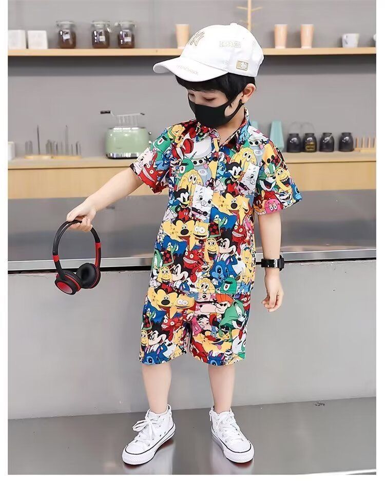 一名戴著口罩和帽子的小男孩手裡拿著耳機。