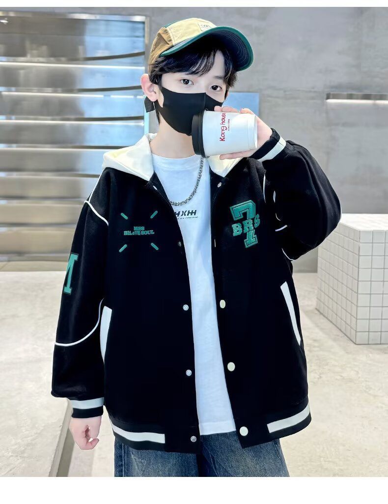 一個戴著口罩和棒球帽的男孩手裡拿著一杯咖啡。