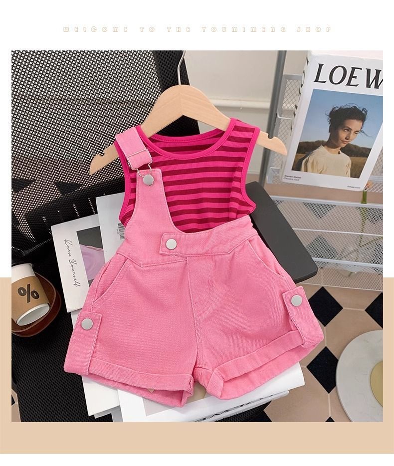 一名女嬰穿著粉紅色工作服和條紋襯衫。