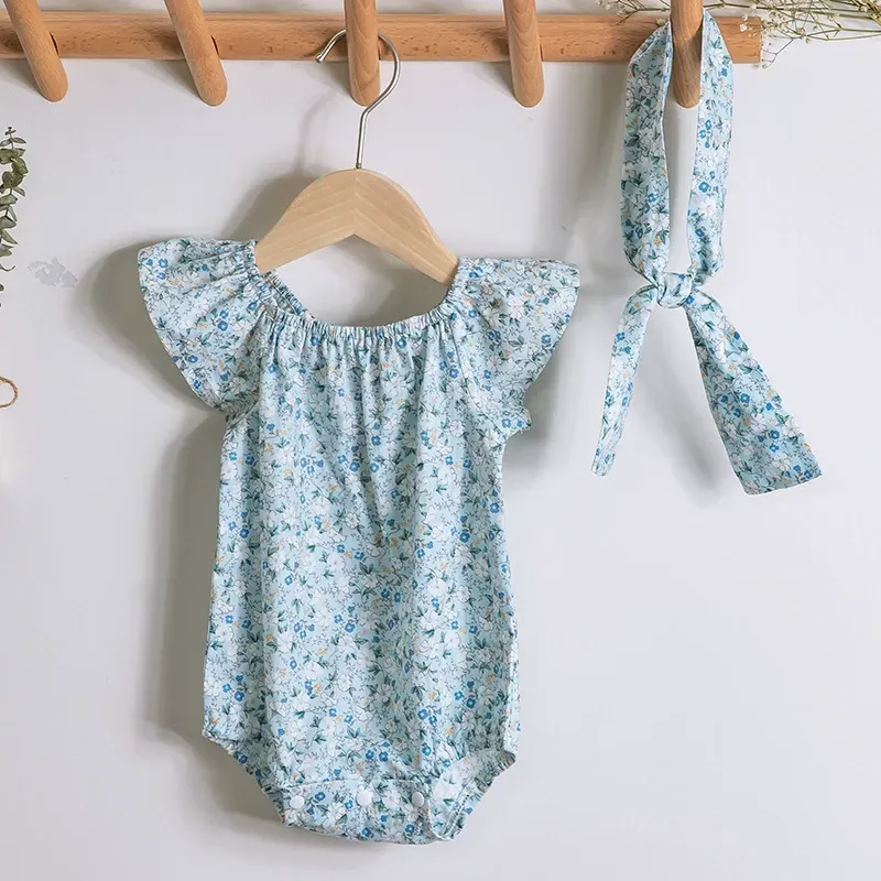 嬰兒的花衣服掛在木衣架上