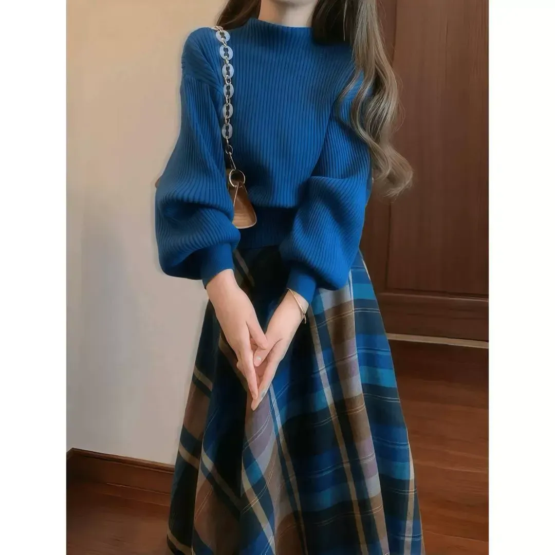 一名女子身穿藍色毛衣和格子裙。