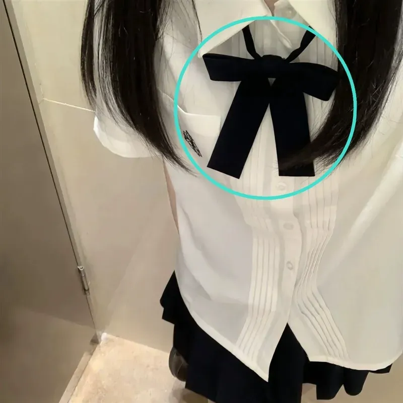 一名身穿白色襯衫、繫著黑色領結的女子