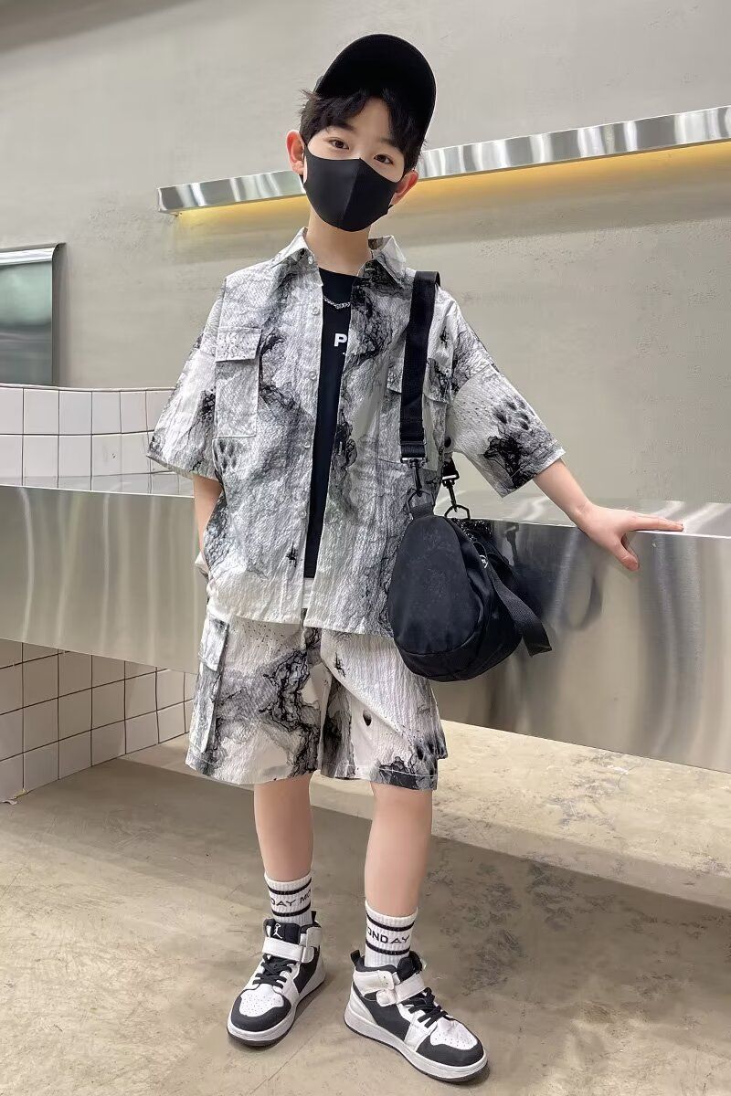 一個戴著口罩和帽子的小男孩站在長椅旁。