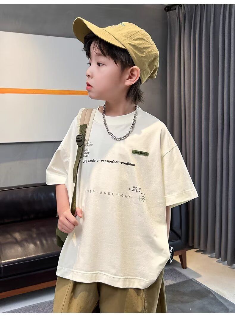 一個戴著帽子和項鍊的小男孩站在客廳。
