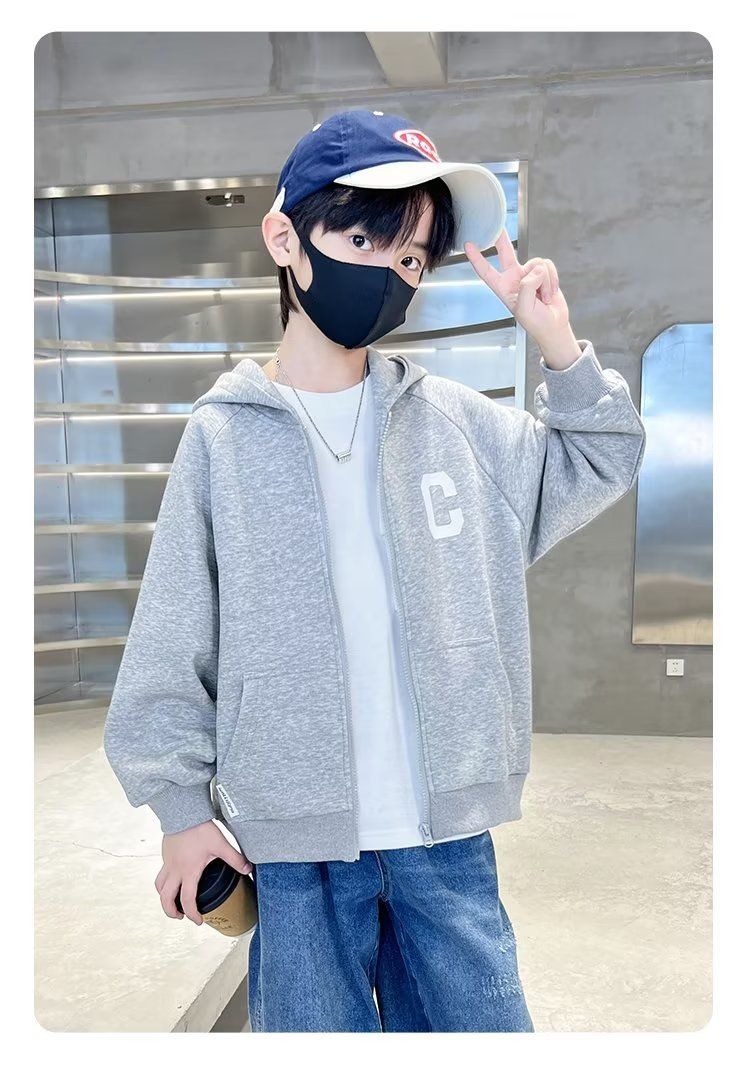 一個戴著口罩和帽子的小男孩站在房間裡。