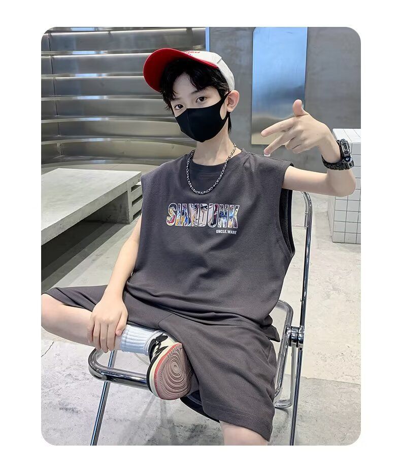 一個戴著口罩和帽子的小男孩坐在椅子上。
