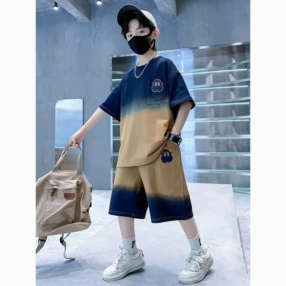 一名戴著口罩、身穿紮染襯衫和短褲的小男孩背著背包。