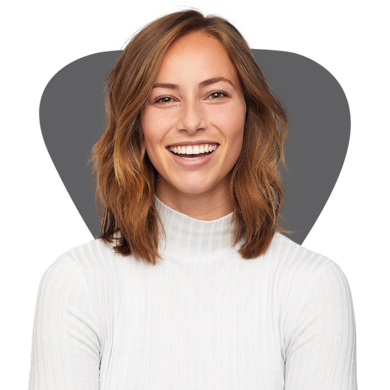 A woman wearing a white sweater is smiling for the camera