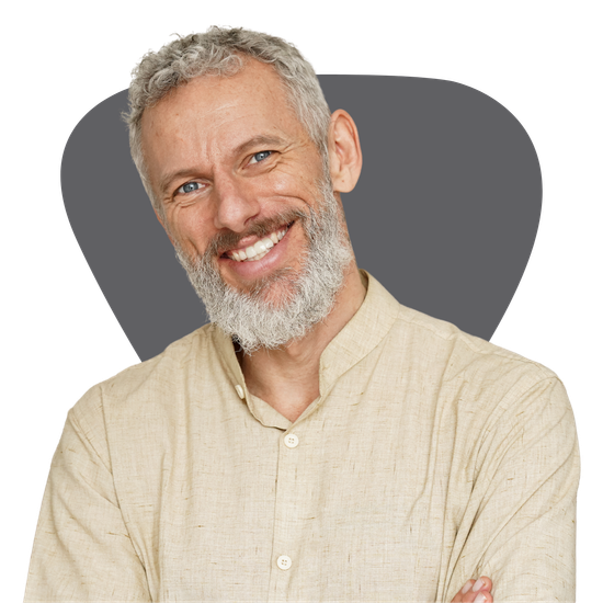 A man with a beard is smiling with his arms crossed.