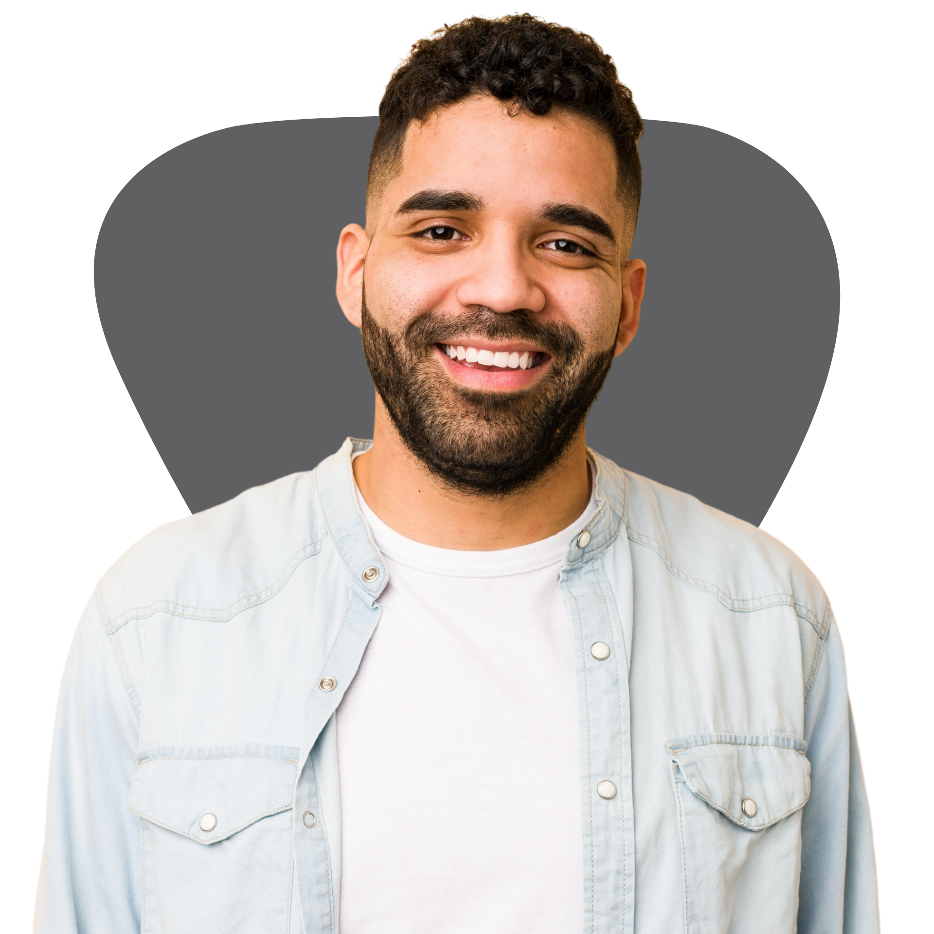 A man with a beard is smiling and wearing a denim shirt.