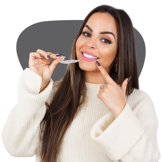 A woman is smiling while holding a clear brace in her mouth.