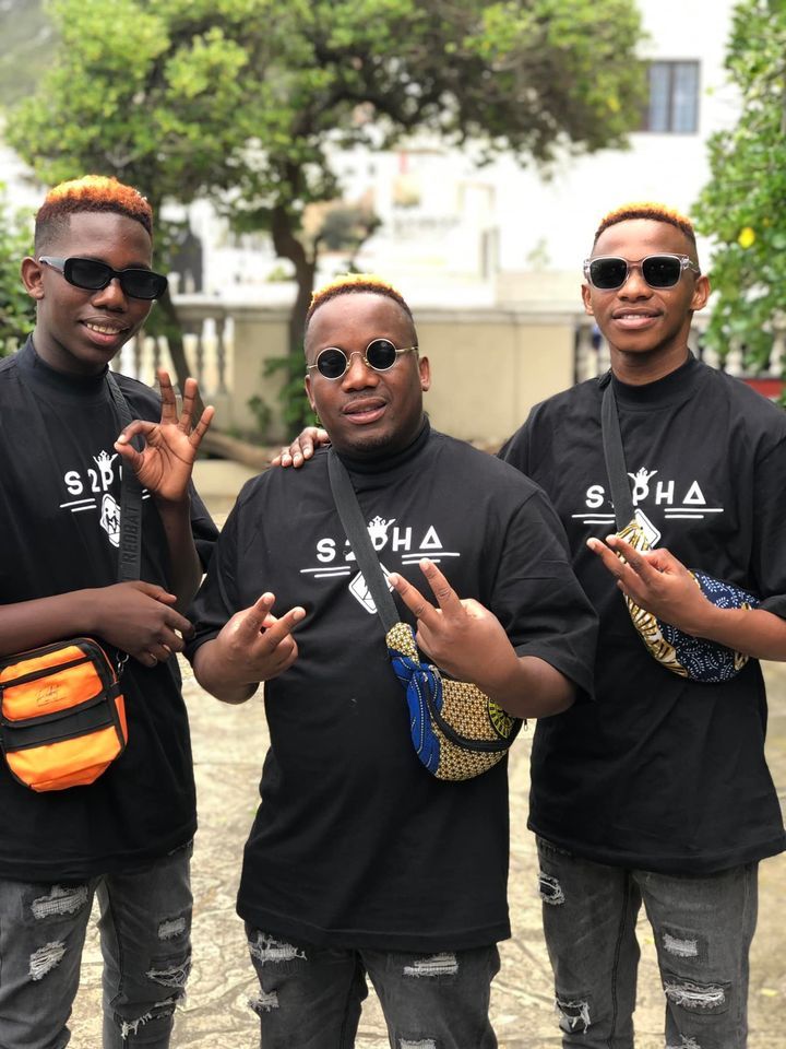 Three men wearing black shirts and sunglasses are posing for a picture.
