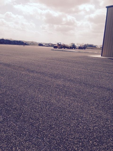 An empty parking lot with a building in the background