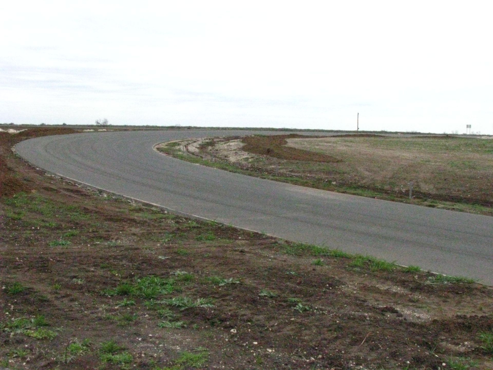 A road that is curved in the middle of a field