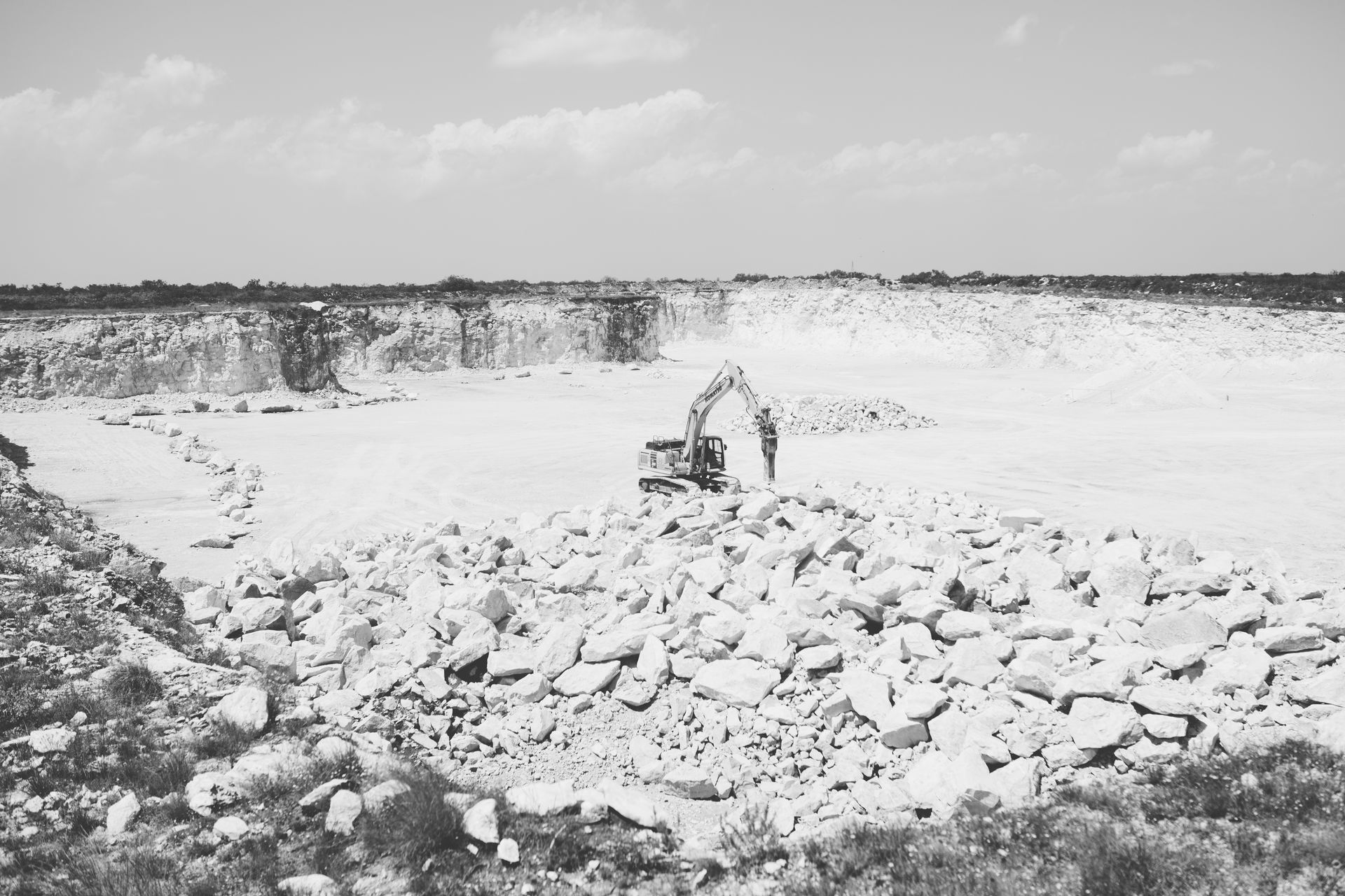 A black and white photo of a large pile of rocks in a quarry.