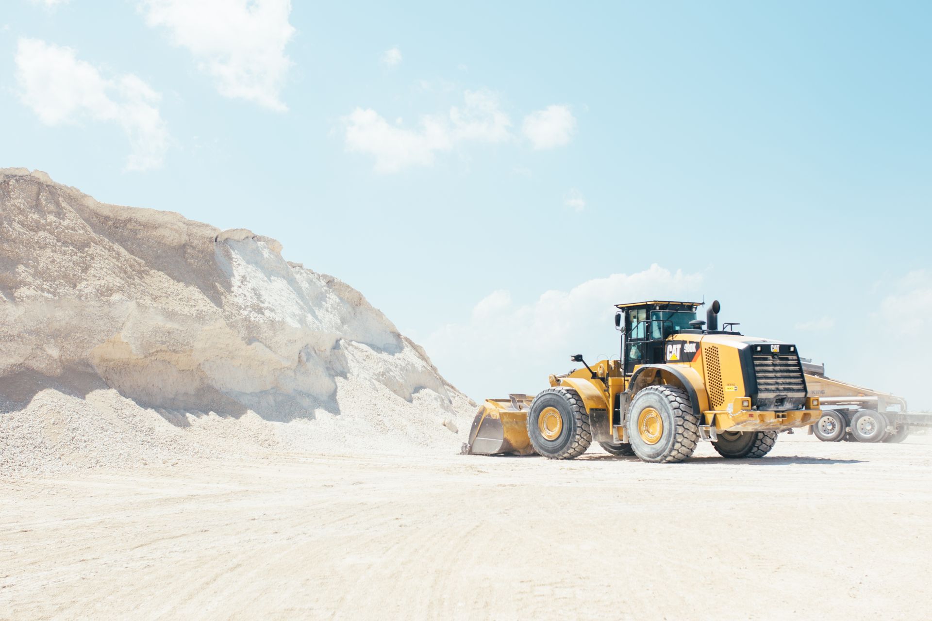 A yellow bulldozer is sitting in the middle of a dirt field.