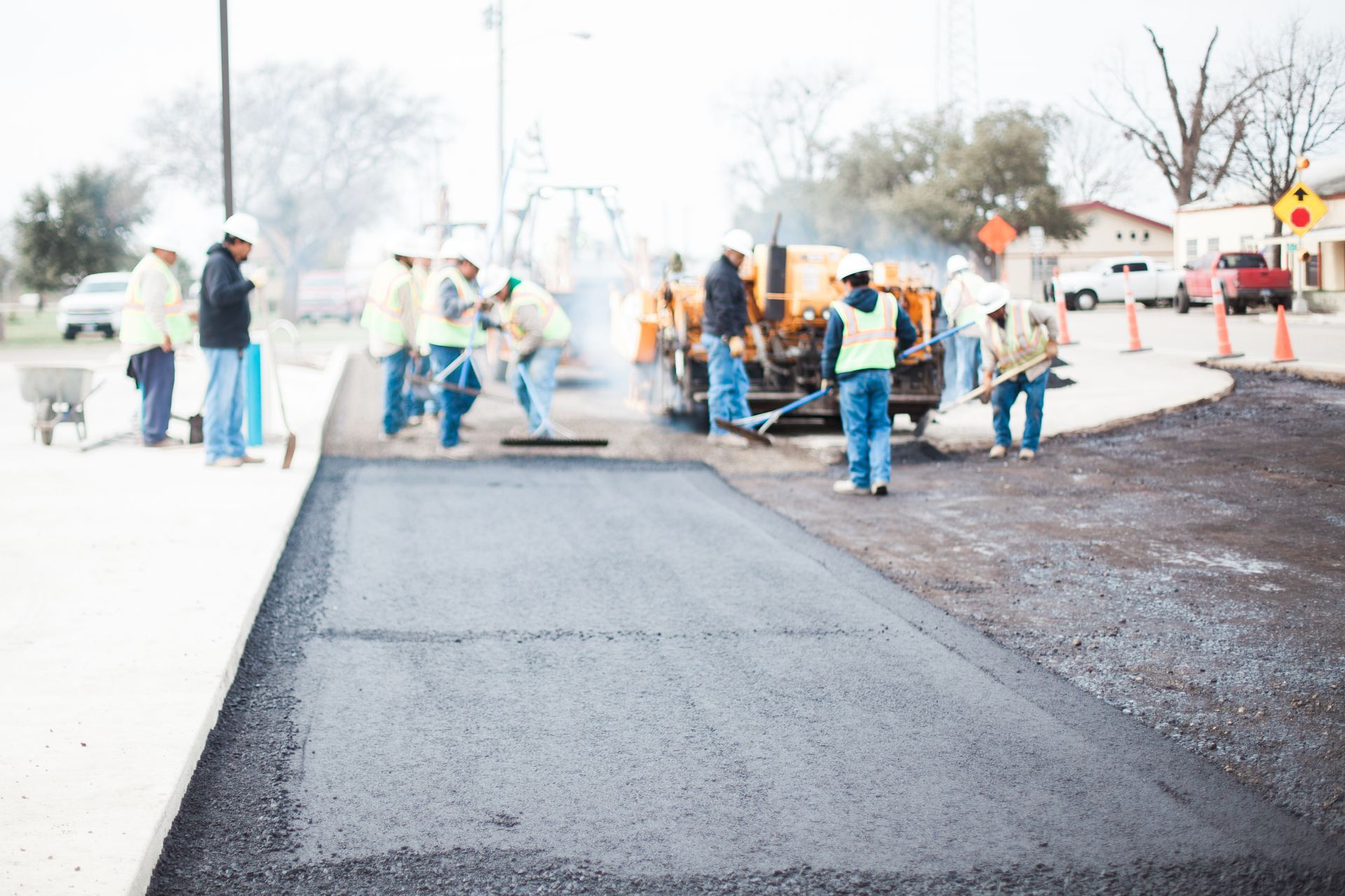 A group of construction workers are working on a road.