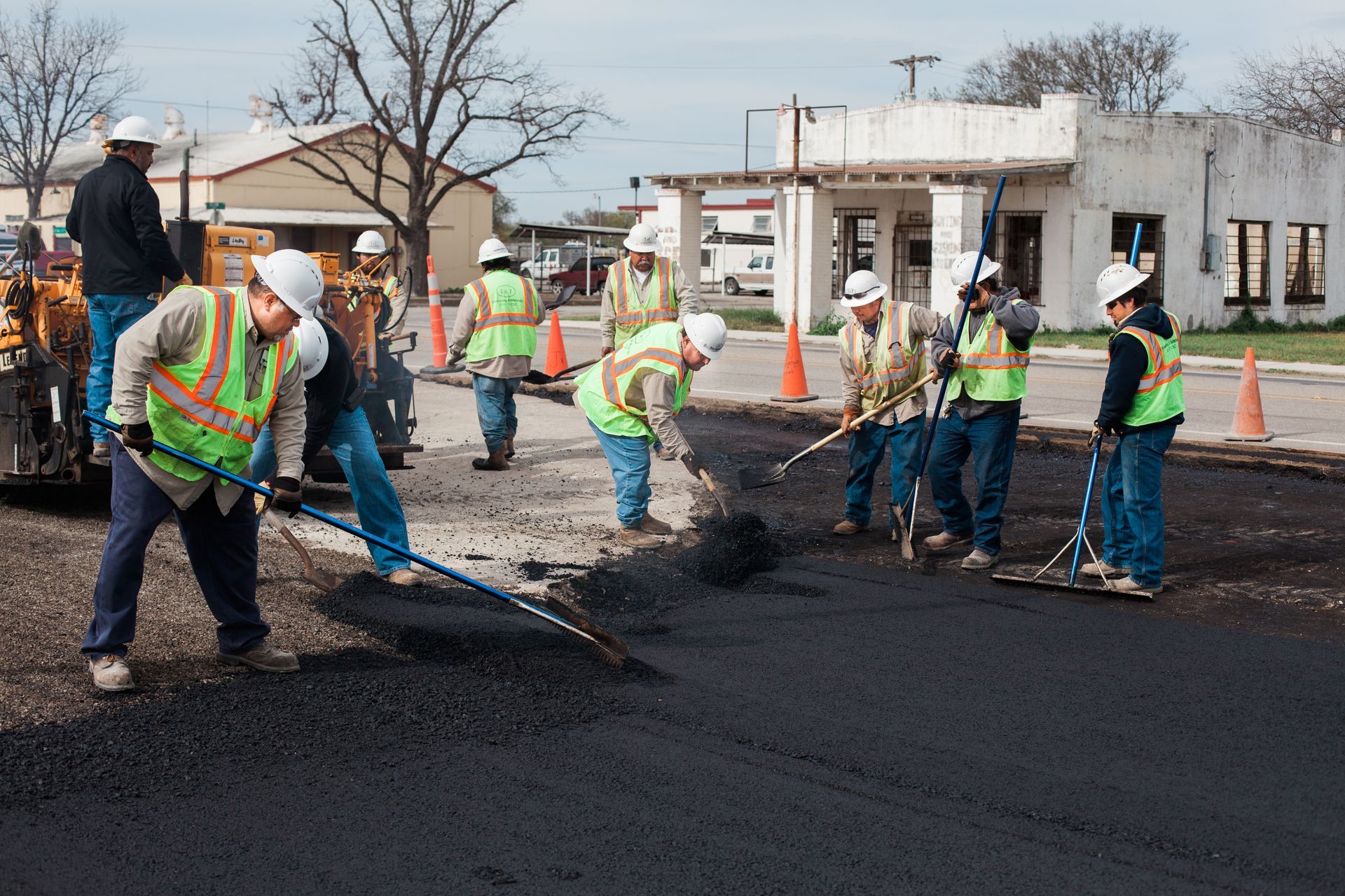 A group of construction workers are working on a road