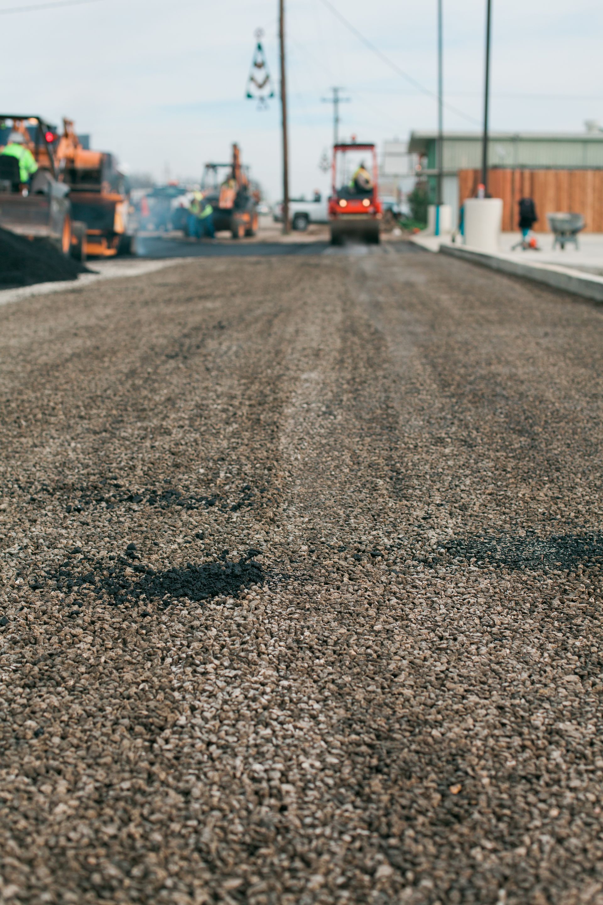 A close up of a road under construction with a lot of machinery on it.