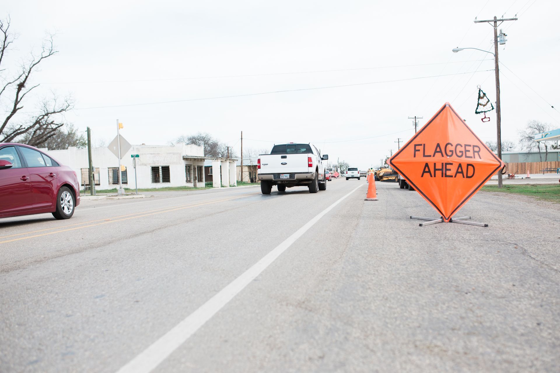 A flagger ahead sign is on the side of the road.