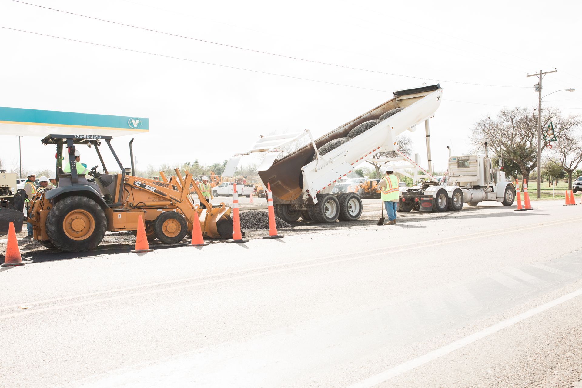 A group of construction workers are working on a road.