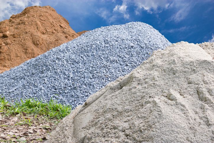 A pile of gravel , sand , and dirt stacked on top of each other.