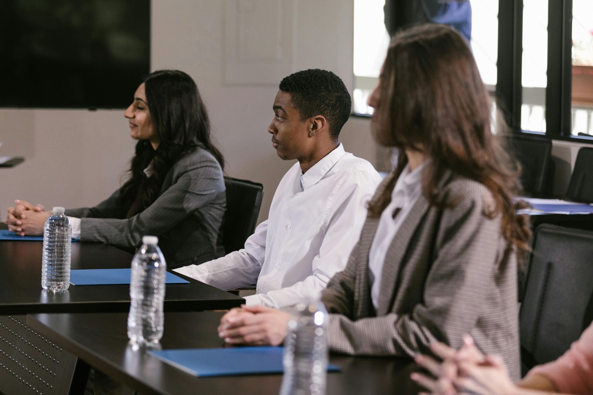 A group of people are sitting at tables in a conference room.