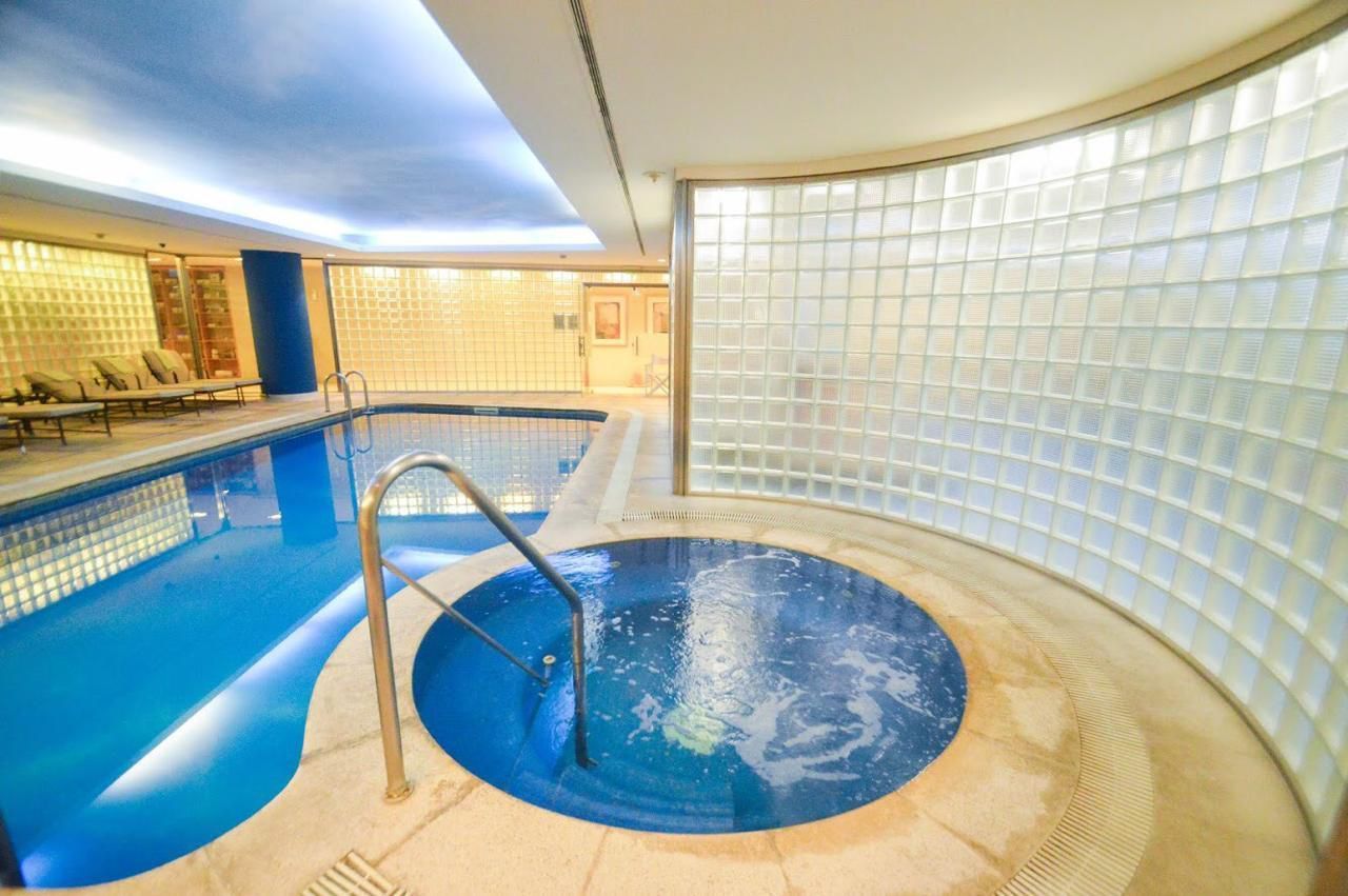 Una gran piscina cubierta con sillas alrededor.