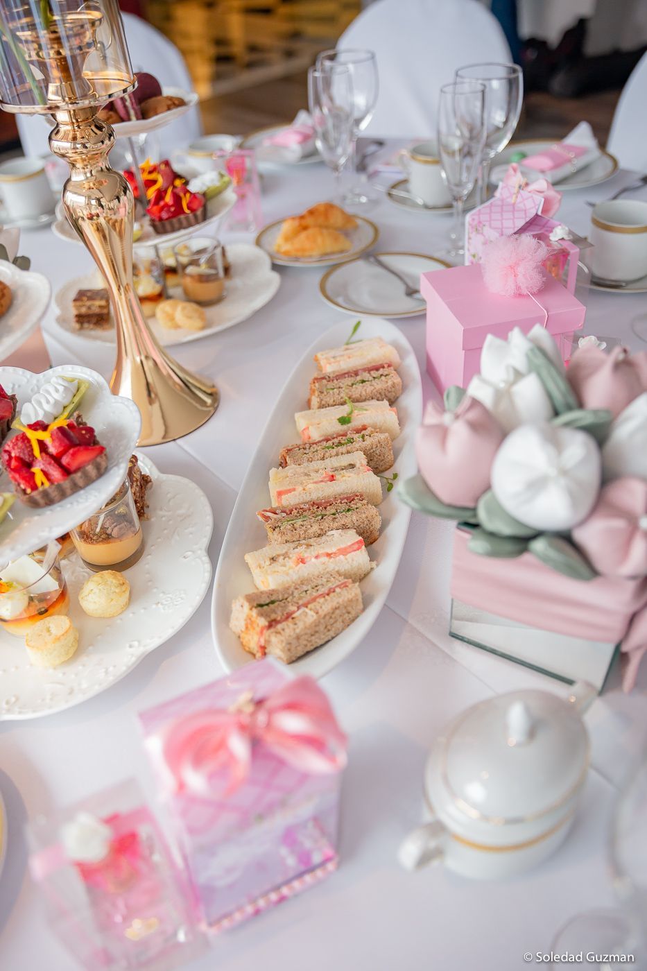 Una mesa con flores y linternas en una habitación con mesas y sillas.