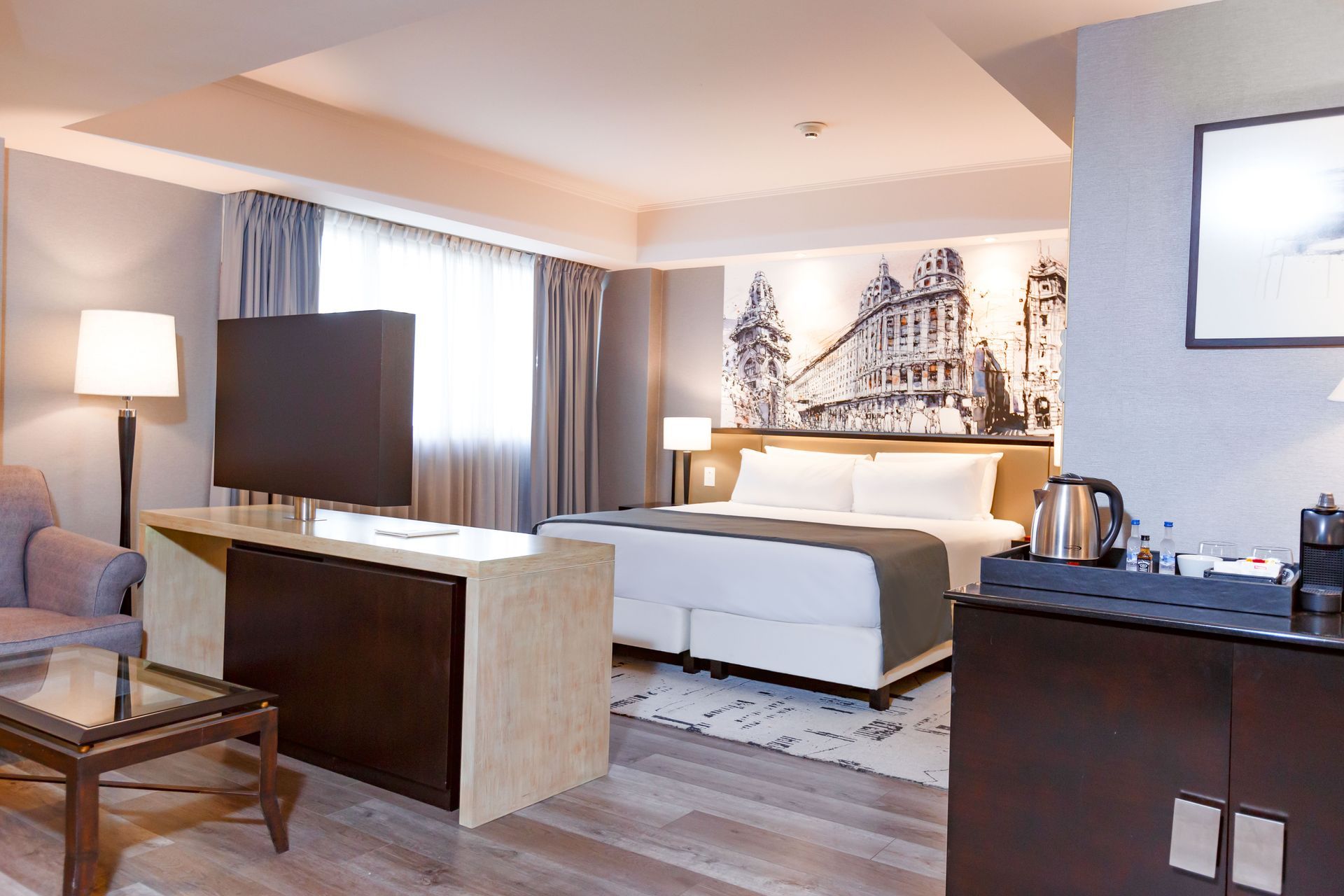 Una habitación de hotel con una cama tamaño king y un televisor de pantalla plana.