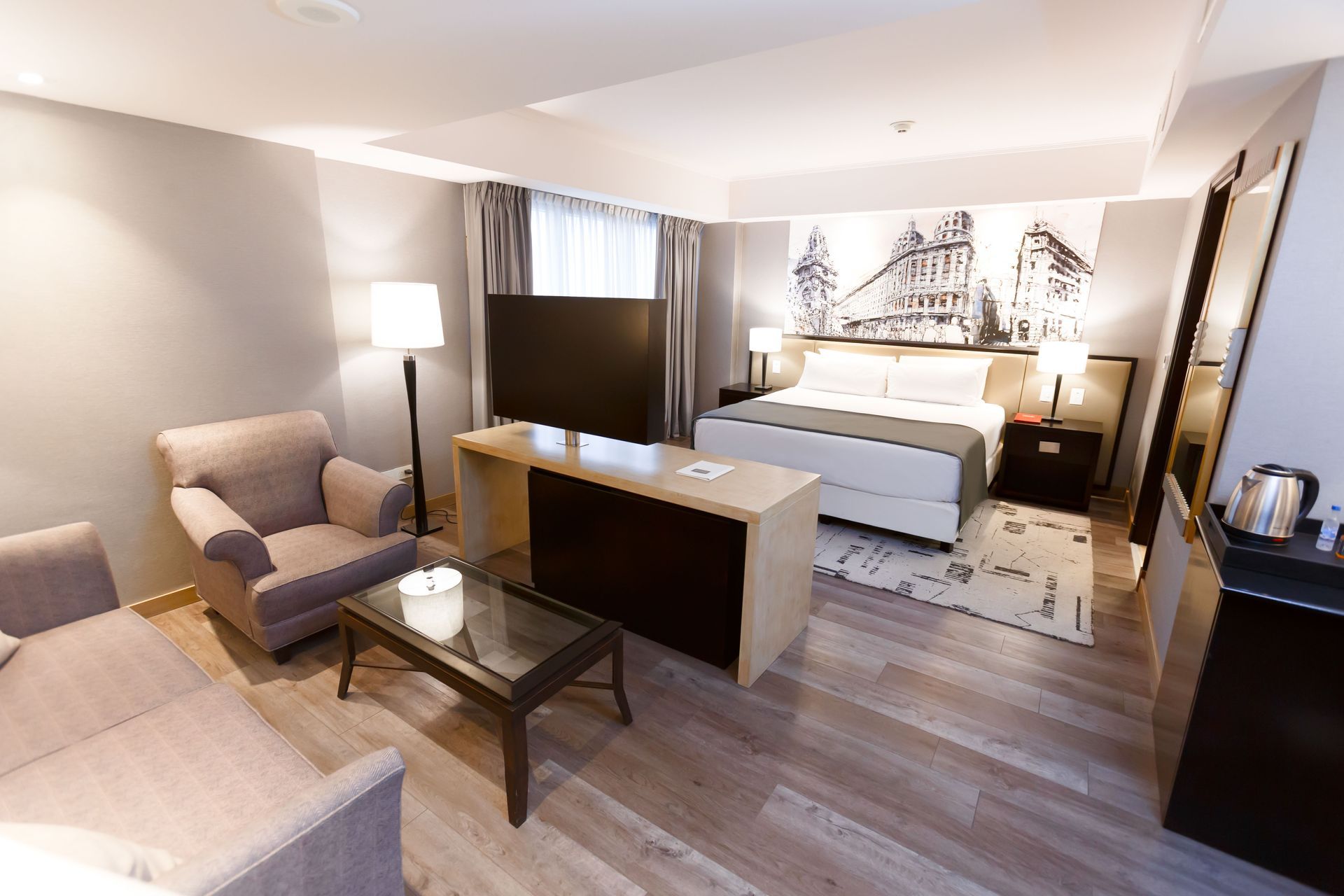 Una habitación de hotel con sofá, silla, mesa y cama.