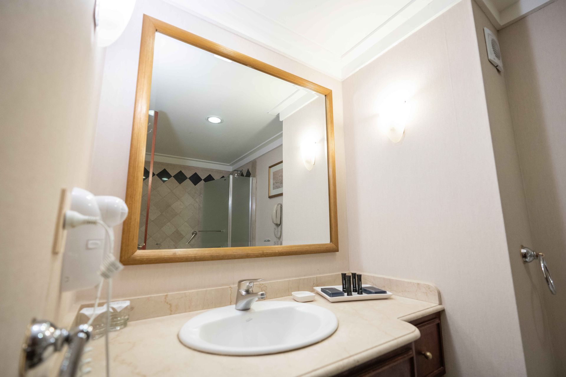 Un baño con lavabo y un espejo grande.