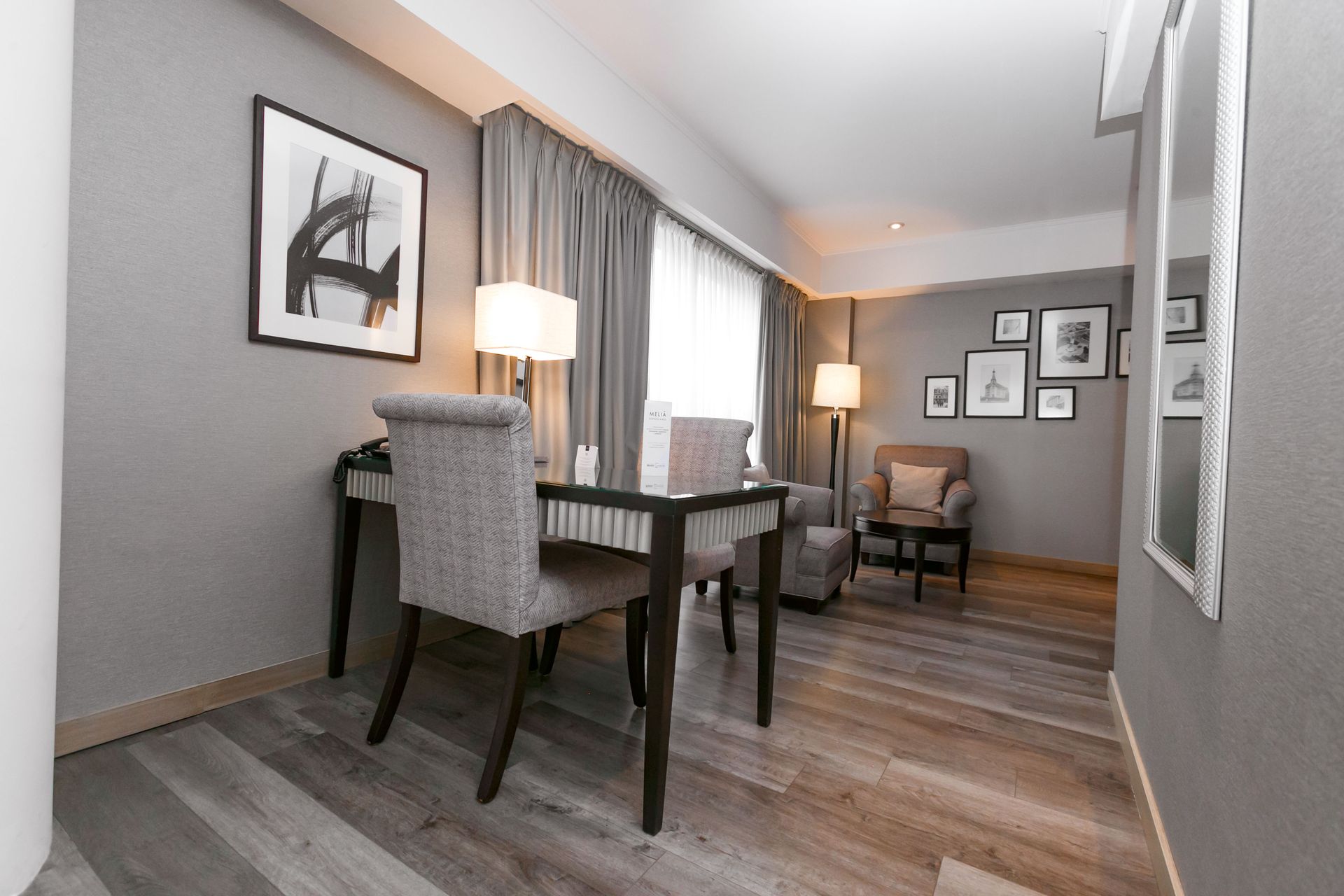 Una habitación de hotel con un escritorio y sillas.