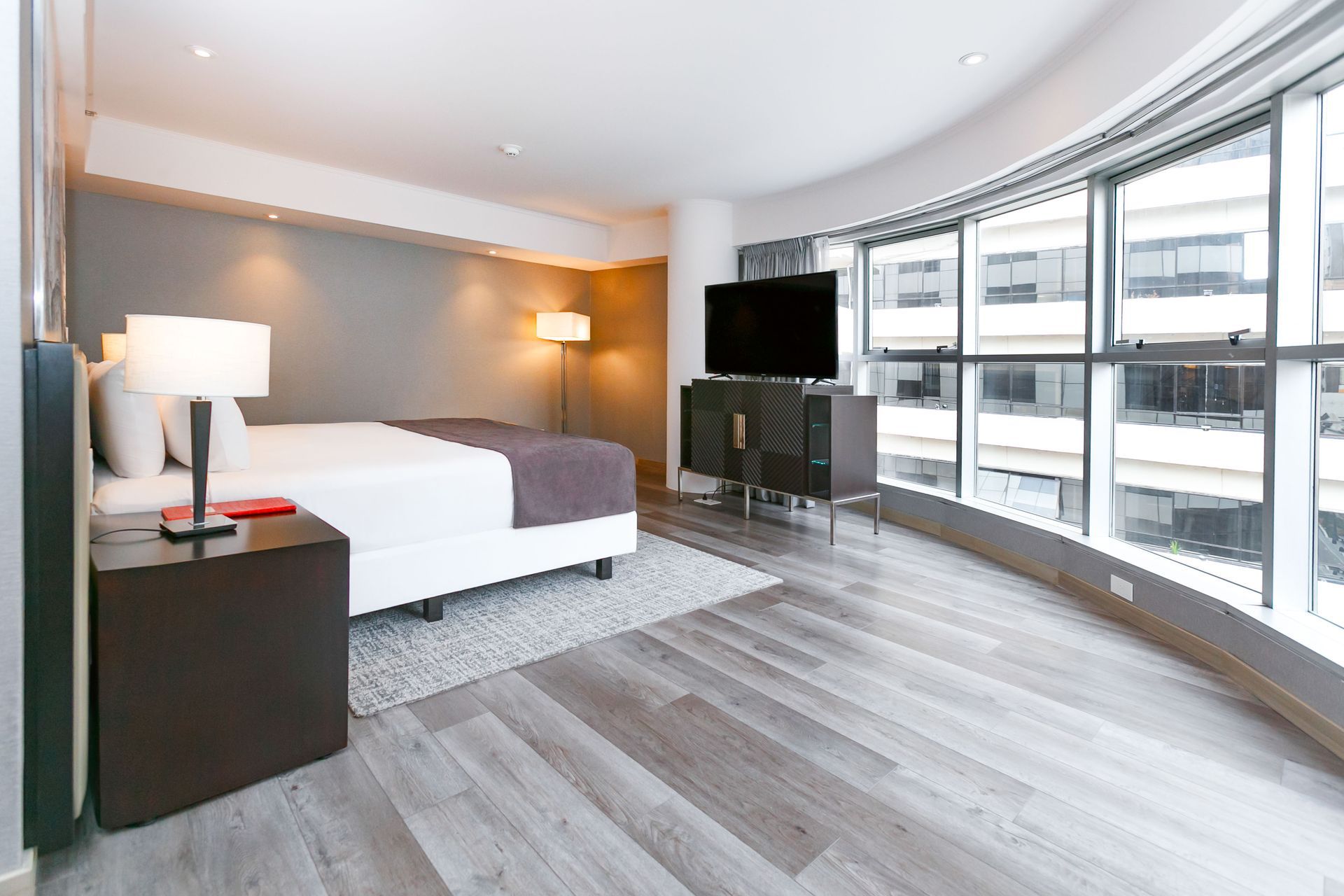 Una habitación de hotel con una cama grande y un televisor de pantalla plana.